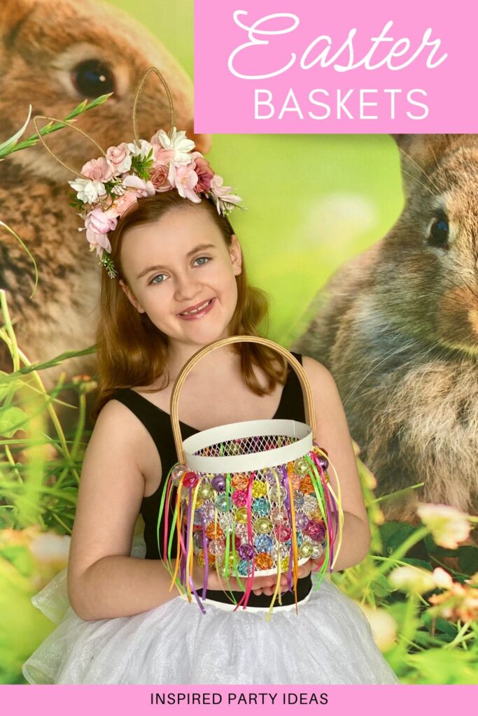 Smiling young girl holding a completed Easter basket decorated with pastel ribbons and sparkling beads, standing in front of a bunny-themed spring party backdrop.