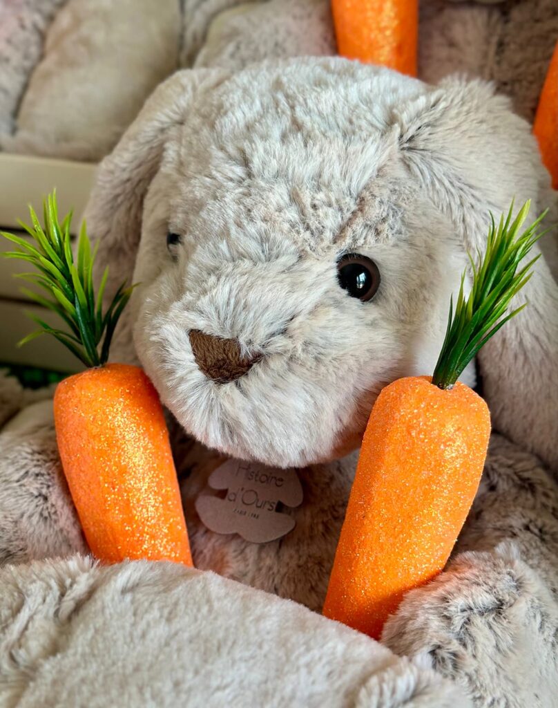 Close-up of a plush bunny’s face with faux carrots visible.