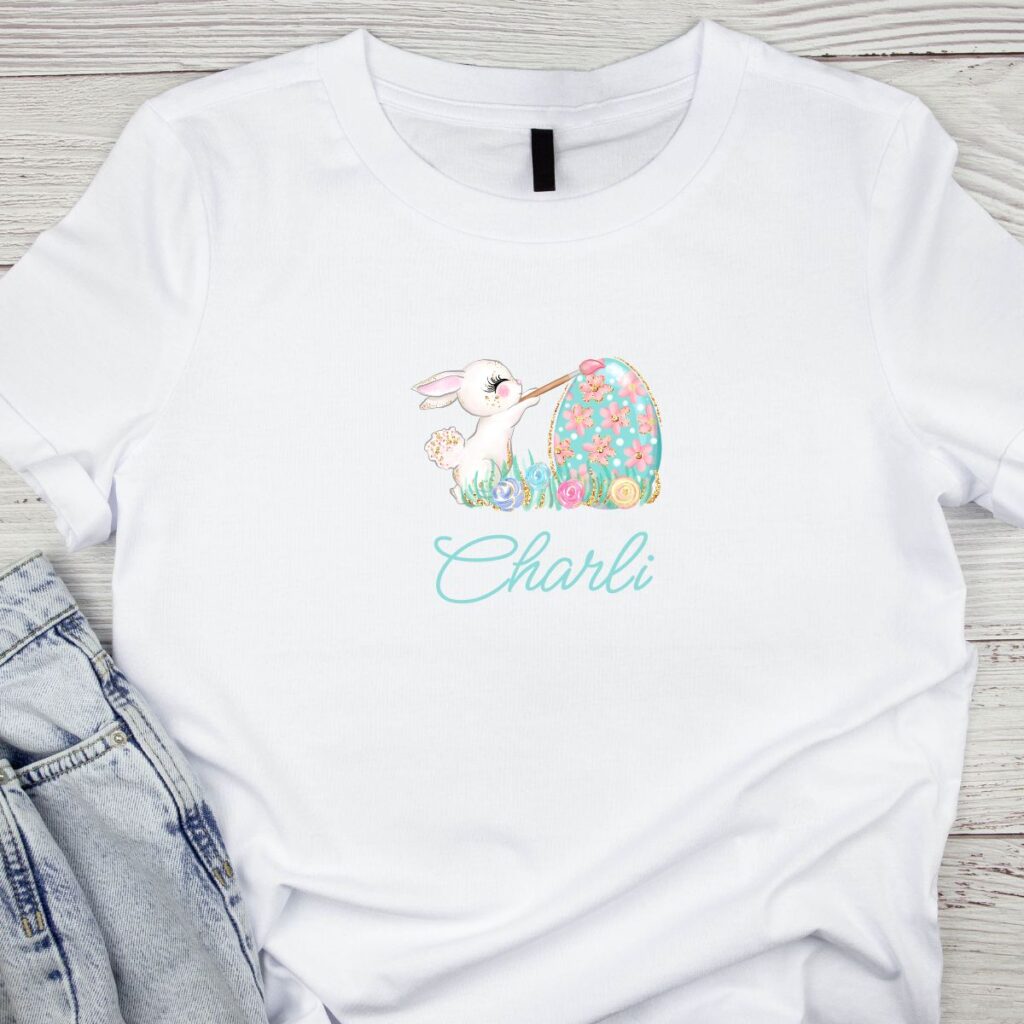 Easter T-shirt with a cute bunny holding a paintbrush and decorated egg, designed by Inspired Party Design.