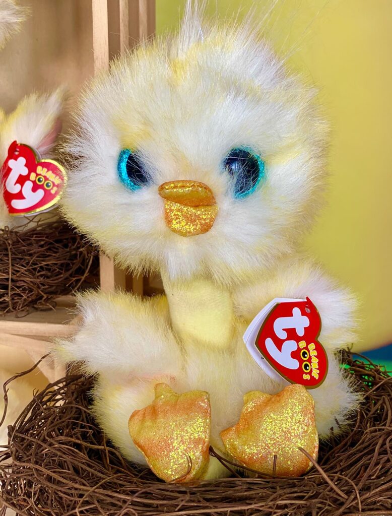 Cute fluffy plush Beanie Boo chick nestled in a faux brown nest, showcasing the chicks used for the party.