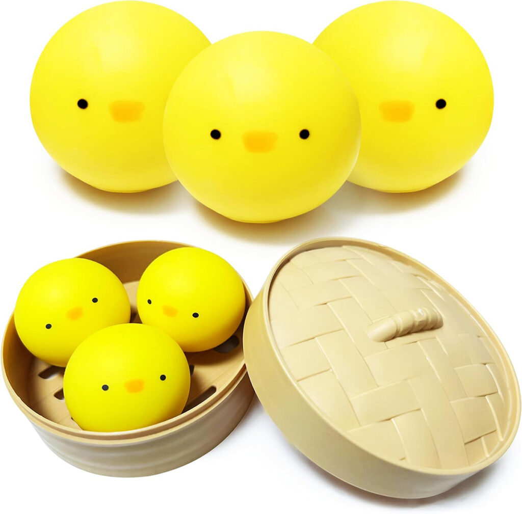 Three yellow chick stress balls inside a bamboo steamer with three more arranged on top, showcasing their soft, squishy texture and cute chick faces.