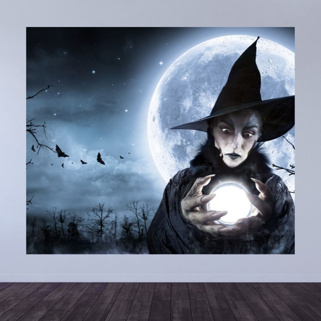 Spooky witch party backdrop displayed on a wall, showing a large witch holding a crystal ball in front of a glowing full moon, promoting magical party backdrops from Inspired Party Backdrops.