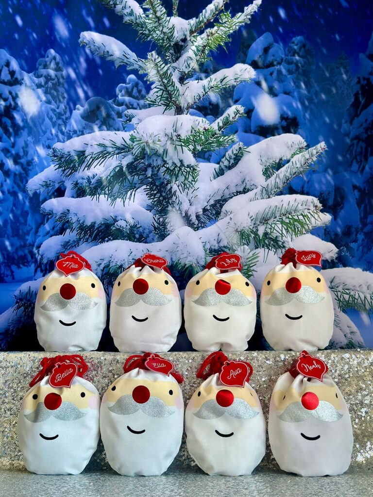 Santa face fabric bags filled with DIY jewelry kits as Christmas party favours for kids.
