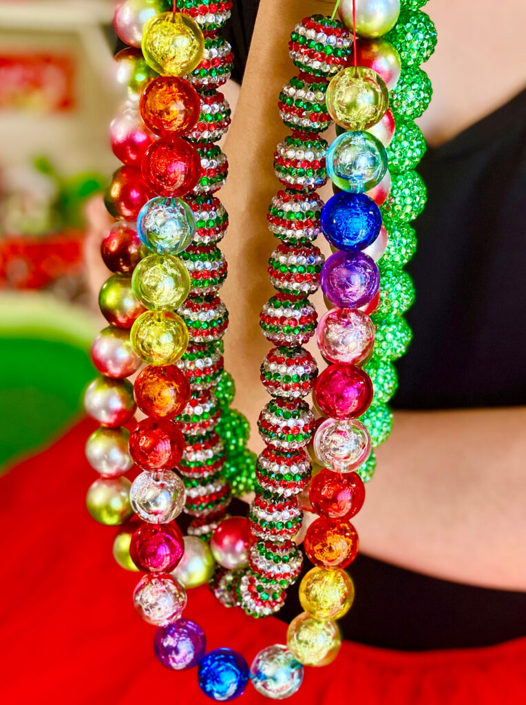 Close-up of DIY Christmas-themed bead necklaces for a kids’ holiday jewelry-making activity.