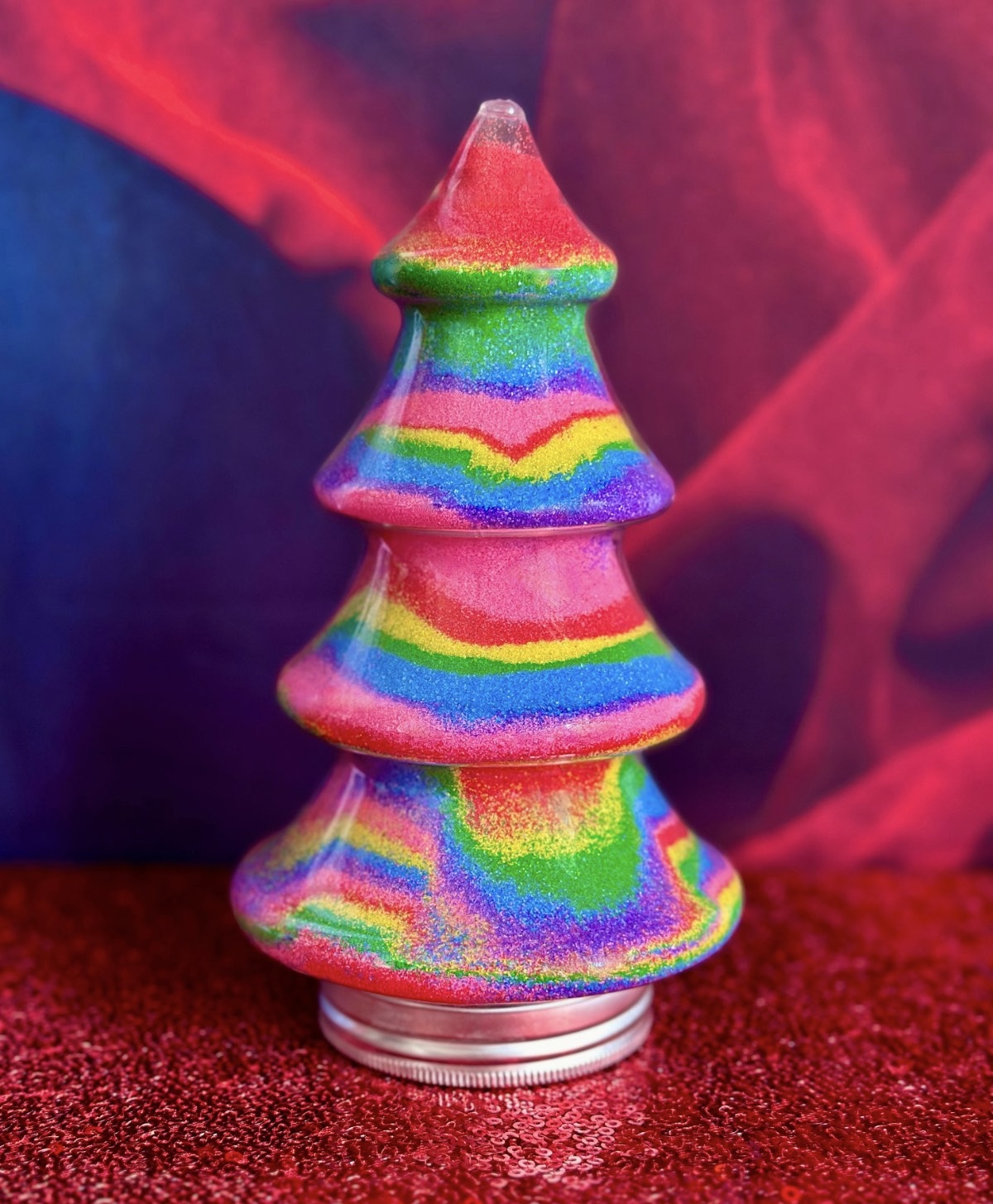 Completed rainbow Christmas tree sand art displayed at a kids Christmas sand art party.