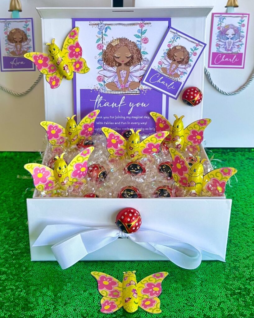Fairy party kids’ chocolate party favor with ladybird and butterfly chocolates in a white gift box on iridescent shred, with a thank you card and personalised fairy name tag.