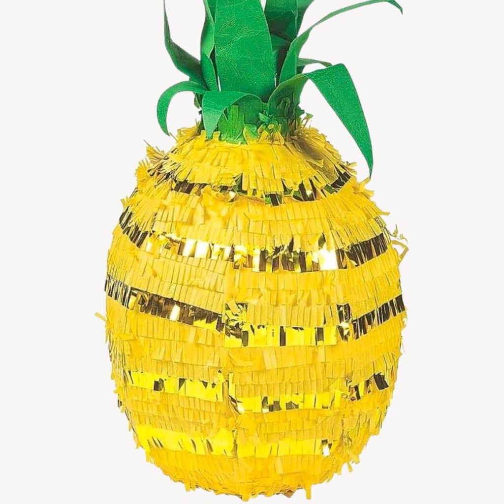 Large yellow pineapple piñata with gold fringe and a green top, filled with candy for a kids pineapple party game.