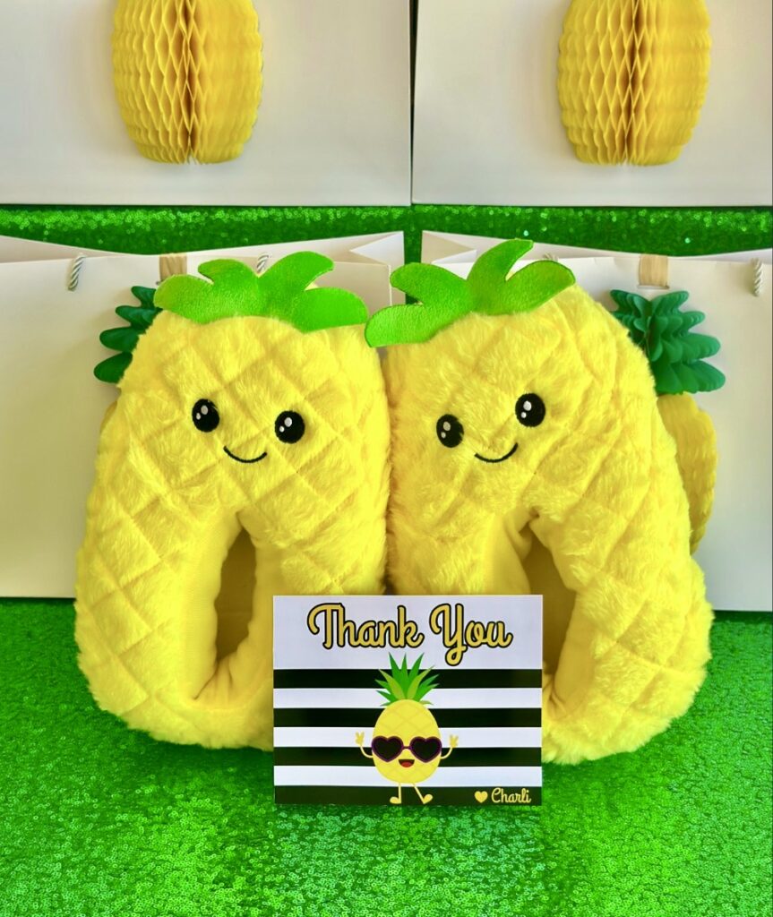 Kawaii pineapple plush slippers kids party favour with a pineapple themed thank you card displayed in front.