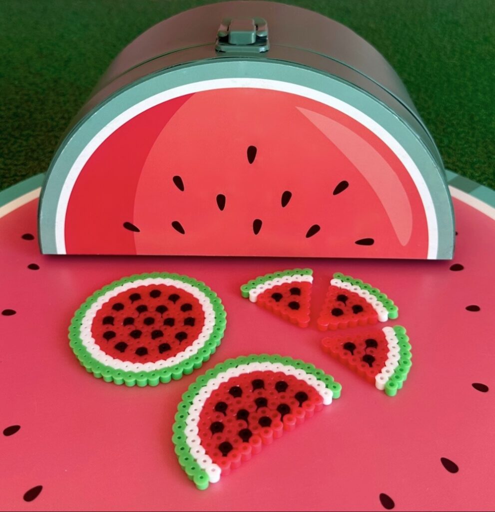 Watermelon Perler bead designs displayed in front of a watermelon-themed party supply tin.