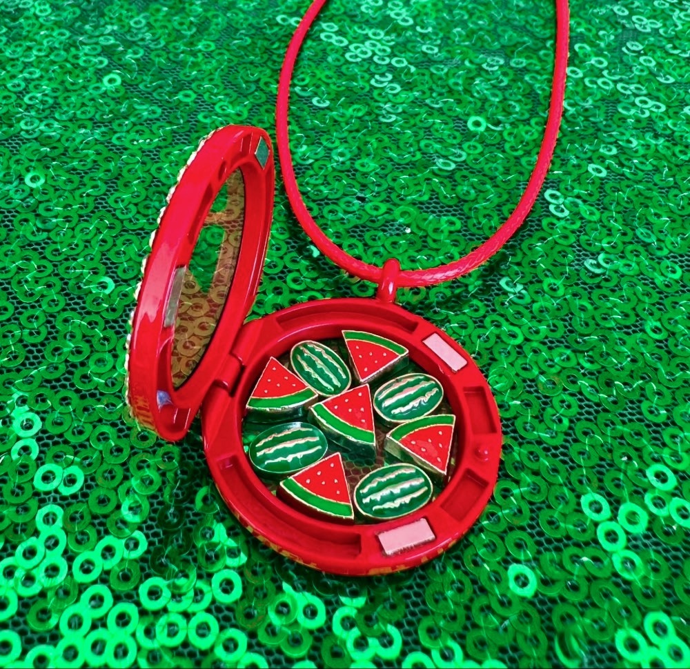 Open red floating locket displaying watermelon slice and whole watermelon charms for kids jewelry.