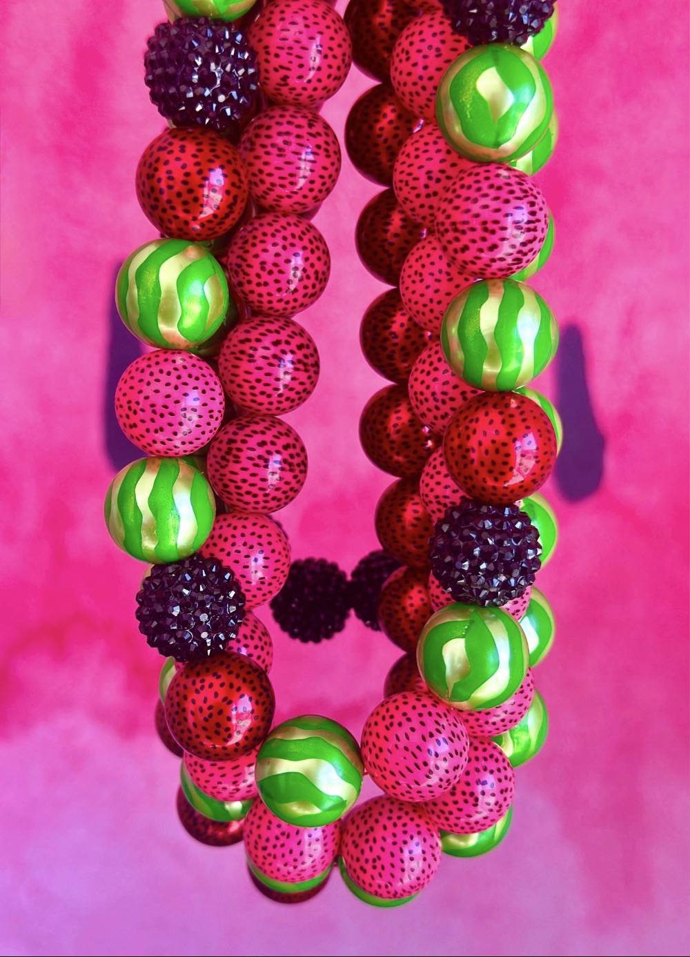 Colourful watermelon bead necklaces on display for a kids watermelon jewelry party.